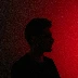 a man standing in front of a red light